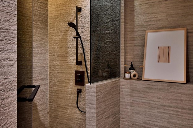 Modern luxury interior design - a bathroom with textured tiles and black hardware.